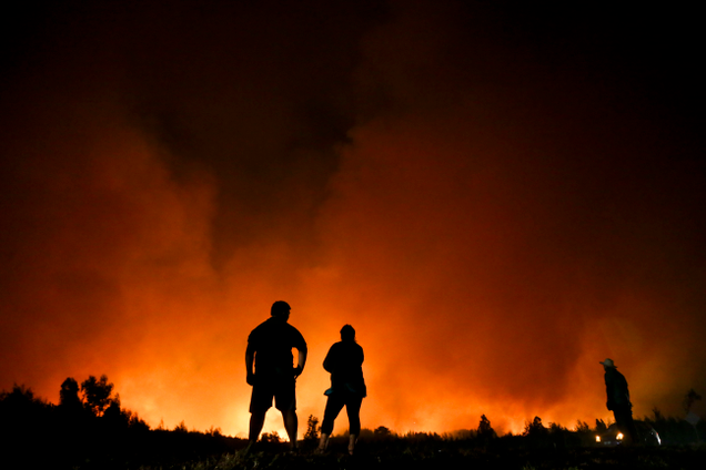 Residents watch as a wildfire sweeps through Portezuelo, Chile, on Jan. 29, 2017. Image: AP Photo/Esteban Felix